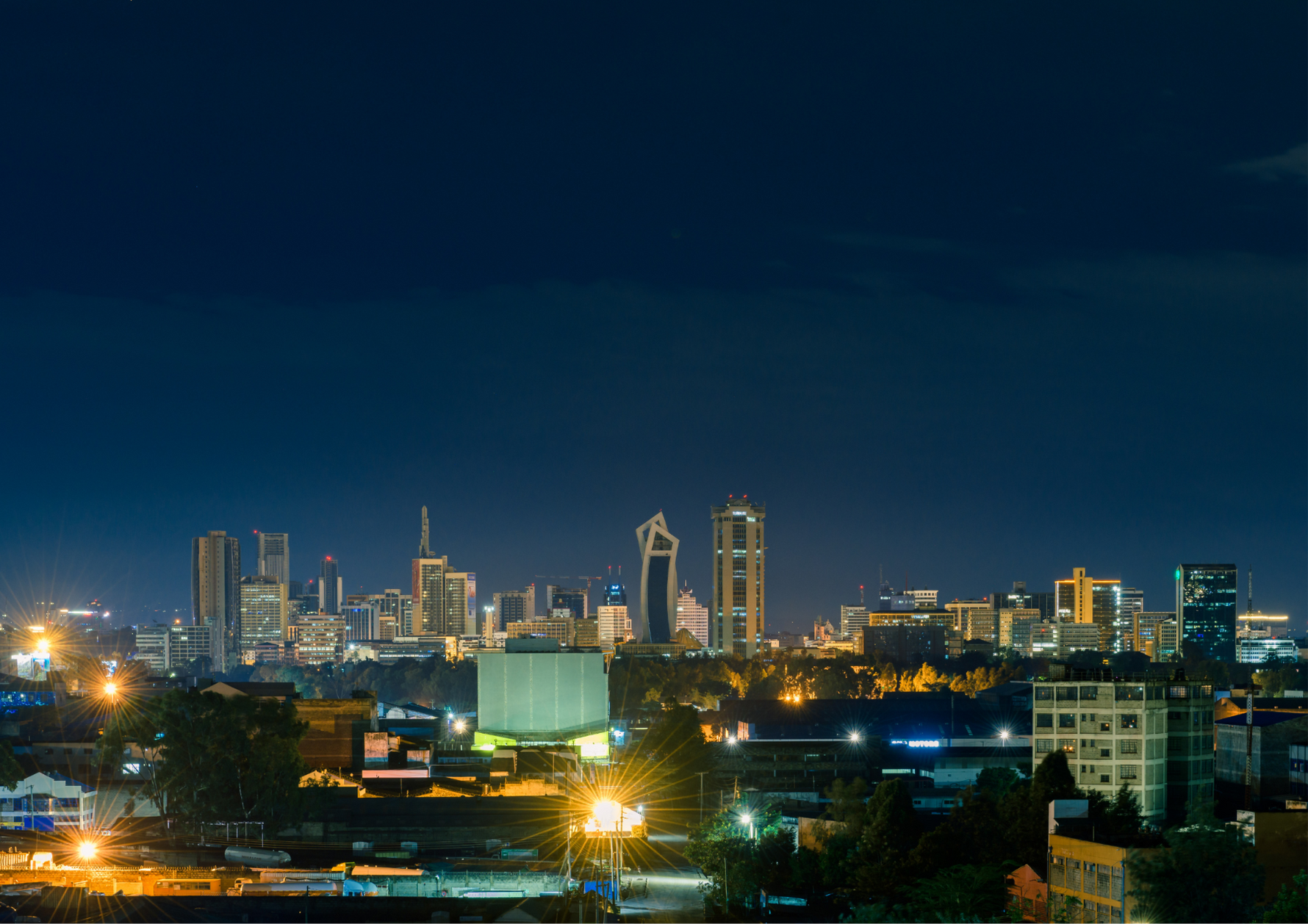 Nairobi City skyline at night with illuminated buildings, representing the urban home of Kirenge Gold premium Kenyan coffee and its vibrant city roots.