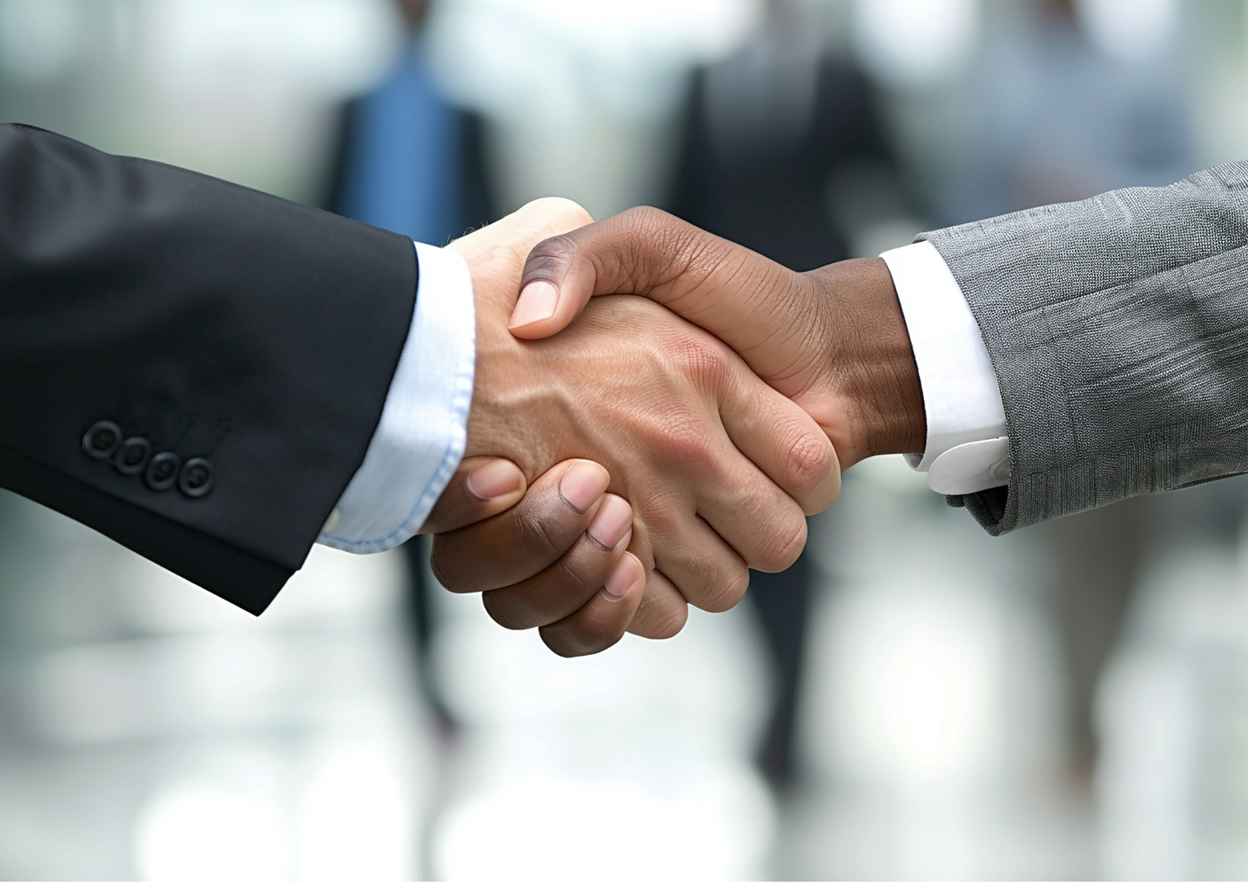 Two people shaking hands with a blurred background, symbolizing partnership and collaboration with Kirenge Gold premium Kenyan coffee business.