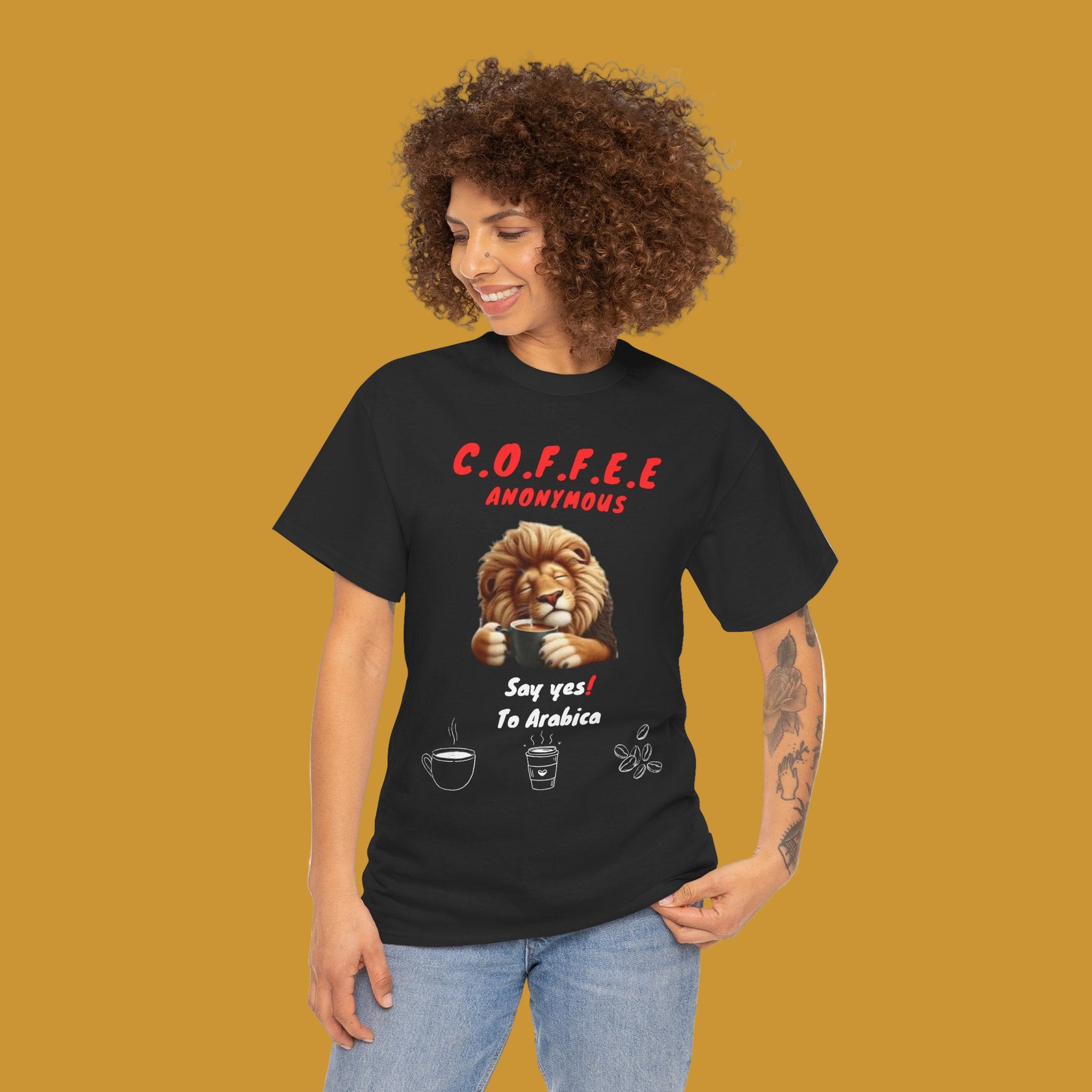 A person wearing a Black t-shirt with a lion holding a coffee cup and text Coffee Anonymous. Kirenge Gold Coffee Anonymous T-shirt